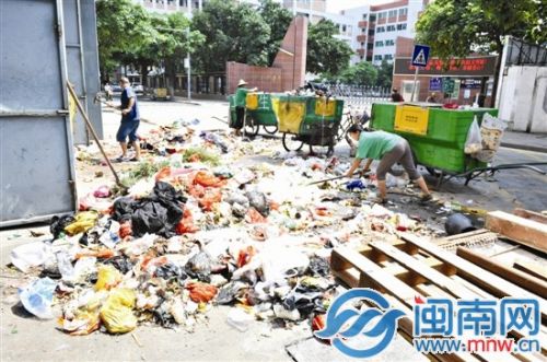 环卫工们正在清理堆积在湖心垃圾中转站门口的垃圾
