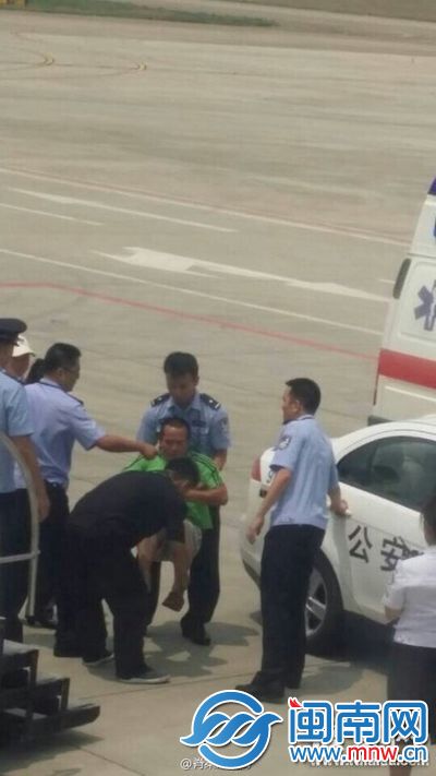 绿衣男子不太配合，警察将他抬进警车