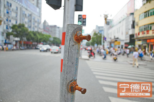 北站路口一处导流岛遮阳伞伞骨裸露铆钉。