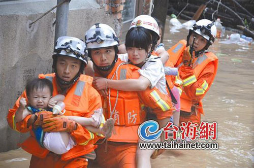 消防员将被困的小孩和大人背出