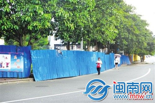 围挡围住了整个人行道，行人冒险走上机动车道