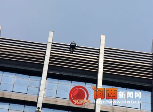 该女子双手搬住栏杆，双脚踩在围栏上，整个身体悬在外面