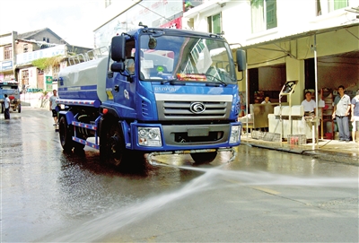 洒水车在集镇街道上进行洒水作业