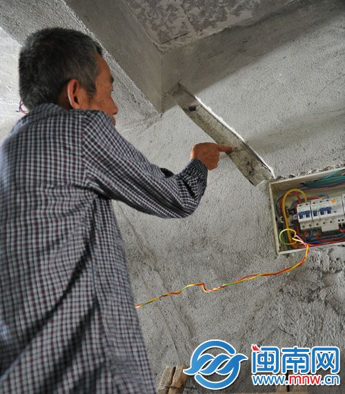 陈先生指出墙壁的裂缝