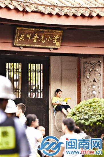 昨日下午5点25分,晋光小学门口,一个小男孩坐在门口石墩上一边看书,一边等家人来接