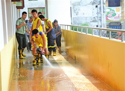 消防官兵用高压水枪清理校园内泥沙