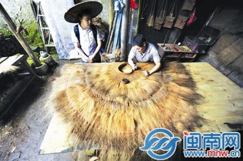 记者（左）体验蓑衣的制作