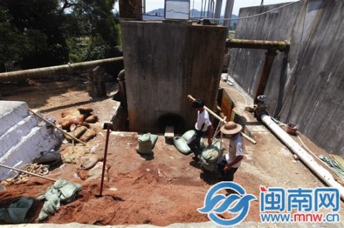 在东坪村东坪自来水厂，工人将过滤池的沙子清出