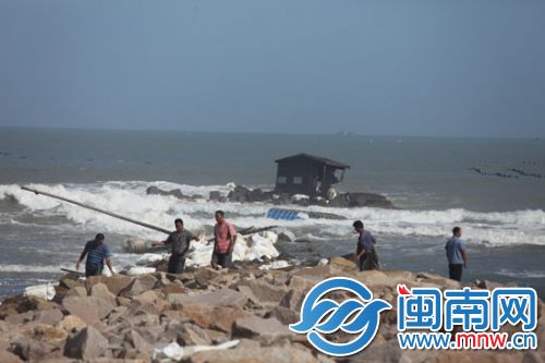 渔民下海想处理翻掉的船只及渔排，因海浪太大作罢