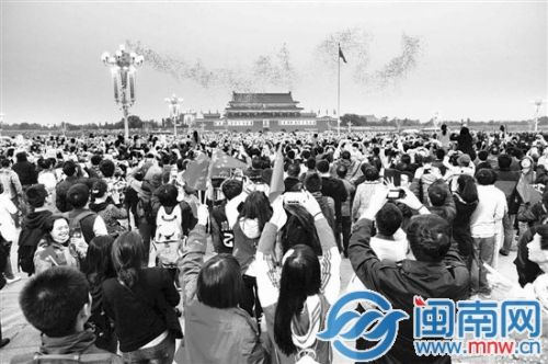 人们在观看升国旗仪式后拍摄腾空的和平鸽与气球