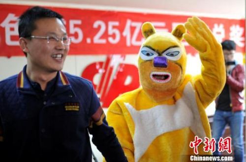 10月13日上午，在山西省福利彩票发行中心，中国彩票史上第三大奖得主身着卡通服装神秘现身兑奖，现场一位男子与其合影。　韦亮　摄