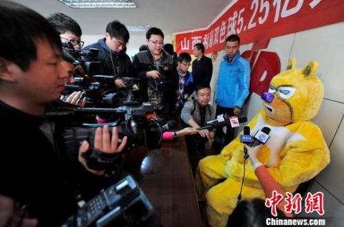 10月13日上午，在山西省福利彩票发行中心，中国彩票史上第三大奖得主身着卡通服装神秘现身兑奖，现场一位男子与其合影。　韦亮　摄