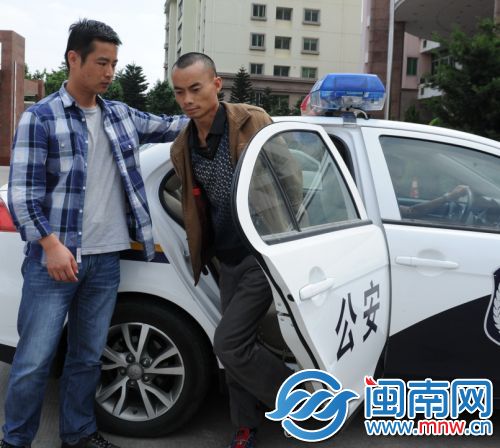 罗某（右）在民警的押解下走下警车