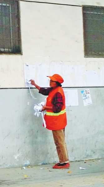 郑州政府街头乱张贴征迁通告涉违规 环卫工人忙清理