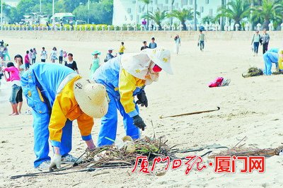 环卫工人清理海滩上的垃圾。（本版图片 记者 黄嵘摄）　