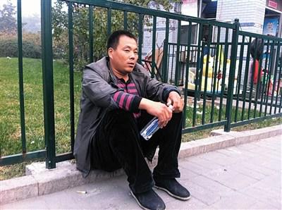 子宣的父亲坐在医院花园里等待妻子。
