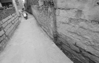 吕顺情在路边建了一堵围墙（右），围墙旁边是排水沟。