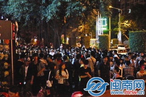 泉秀街与沉洲路交叉口的酒吧门口聚集大量看热闹人群，行人难以通行