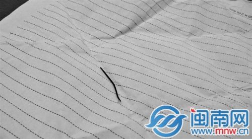 绣花针呈黑色，一头有针孔，中部弯曲