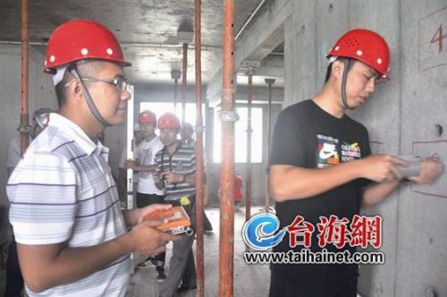 ▲工程质量监督员正在对墙体进行硬度勘测