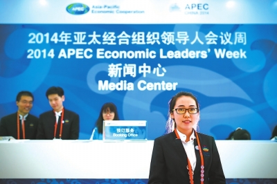志愿者阿娜尔，22岁，她的职责是为记者提供预订服务（11月6日摄）。她身上穿的衣服由福建柒牌设计生产。