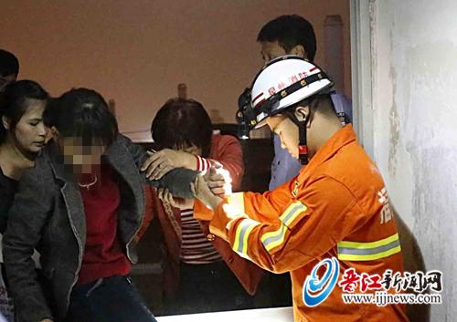陈女士女儿和陈文荣局长扶着她从楼顶边缘下来。
