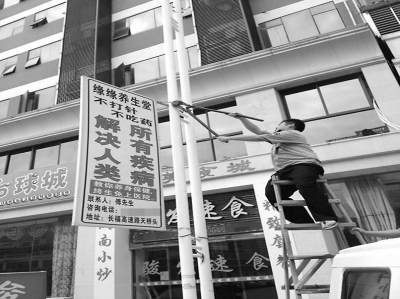 执法人员正在拆除广告牌。