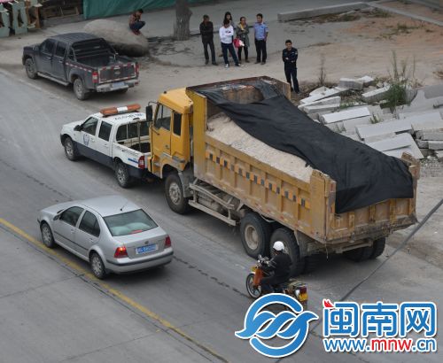 渣土车和执法车僵持在路边