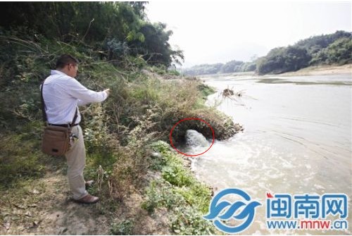 山城镇坎仔头村，环保局工作人员拍照记录排污口（画圈处）