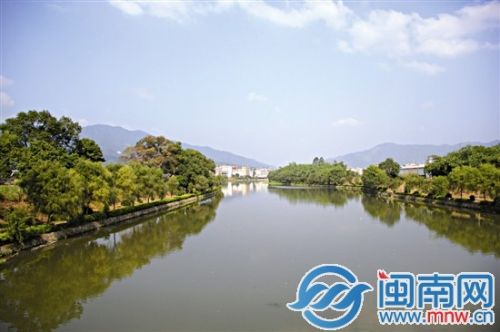 南靖龙山新大桥上游，河岸两边种满绿树
