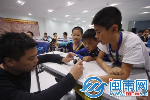 摄影老师为小记者讲解快门光圈(资料图)