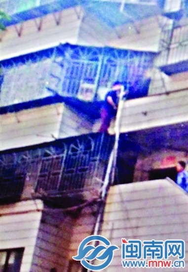 黑衣侠（画圈处）就是从3楼楼梯口，沿着防盗窗，爬上4楼的小平台，用锤子敲掉事发套房防盗窗上的两根铁管（箭头所指处），此时已准备离开