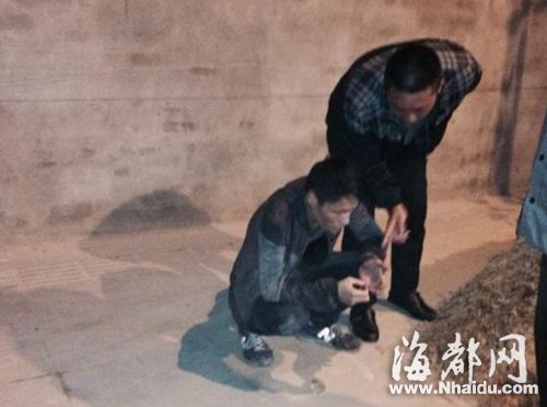 被抓住的歹徒(蹲坐者)
