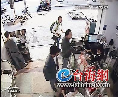 ▲监控视频显示，男子正试图将店员绕晕，边上围观男子或是其同伙