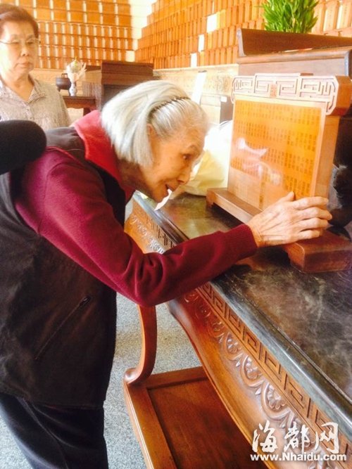 老人用手輕輕地?fù)崦逃戌姵琏蚊值撵`位，潸然淚下