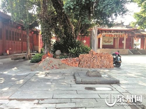 正殿前石庭堆着沙土砖头，停着电动车