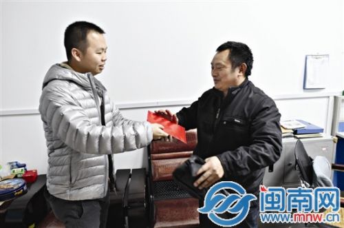 黄先生（左）把红包塞给李师傅（右）以示感谢，但双方反复推让