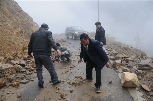 高德荣（右前）在下乡路上清理塌方的落石。王靖生