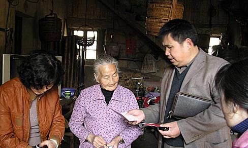 2009年，原莆田市台胞副会长廖明来（右二）向困难台胞送上补助款。