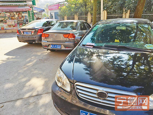 停车位被锁，3辆轿车只能停在行道树下，其中一辆已被贴上罚单。