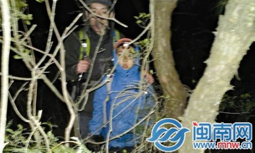 父子俩被找到时，躲在草丛中等待救援