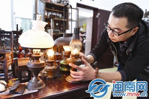 傅先生在精心调节一盏古油灯