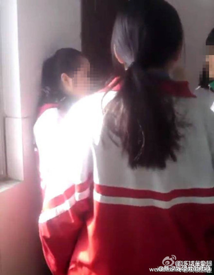 画面中挨打的女生因为没有穿校裤扣分被同学围攻用耳光“教育”
