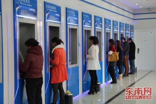 图为市民在自助存取款机前办理业务