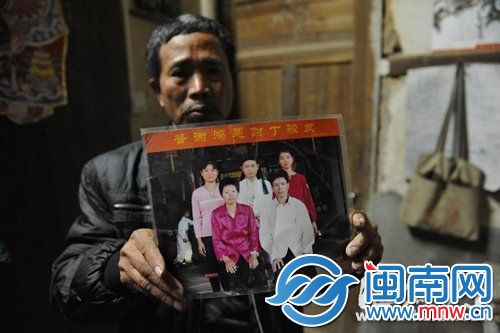 老张举着全家福说，儿子欠下的债，他一定会还清