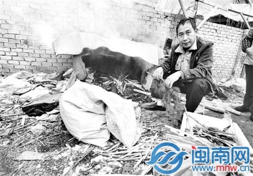 記者在一處角落里，找到了這個燒樹葉熏肉的男子