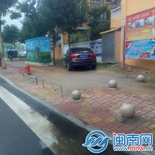 小车停在人行道上，车主还设栏杆上锁