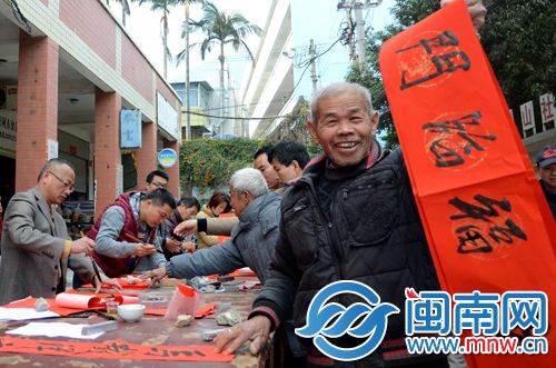 老伯手举春联，笑对镜头