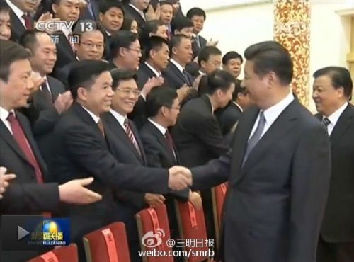 图为习大大会见文明城代表时，与三明市委书记邓本元亲切握手。
