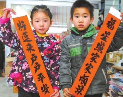 两位小朋友展示一对白额春联